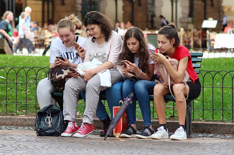 Group of people absorbed in their phones, heads down
