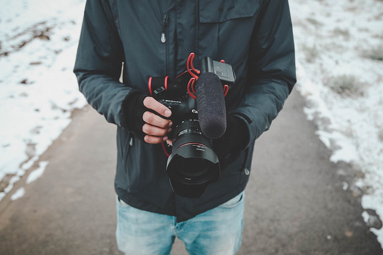 A videographer holding a camera and microphone