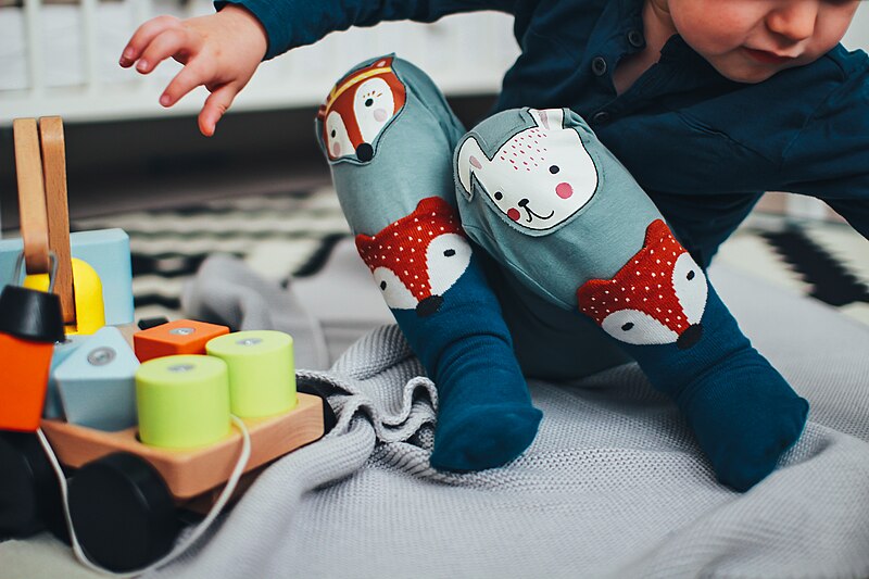 A toddler playing with a toy on the floor — an ordinary everyday moment