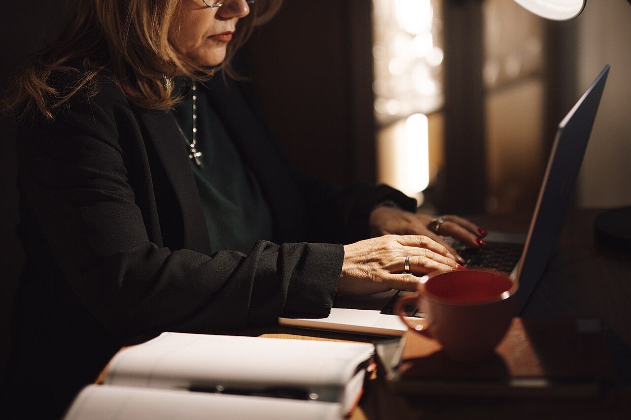 A seller working through store data on a laptop at a home office desk
