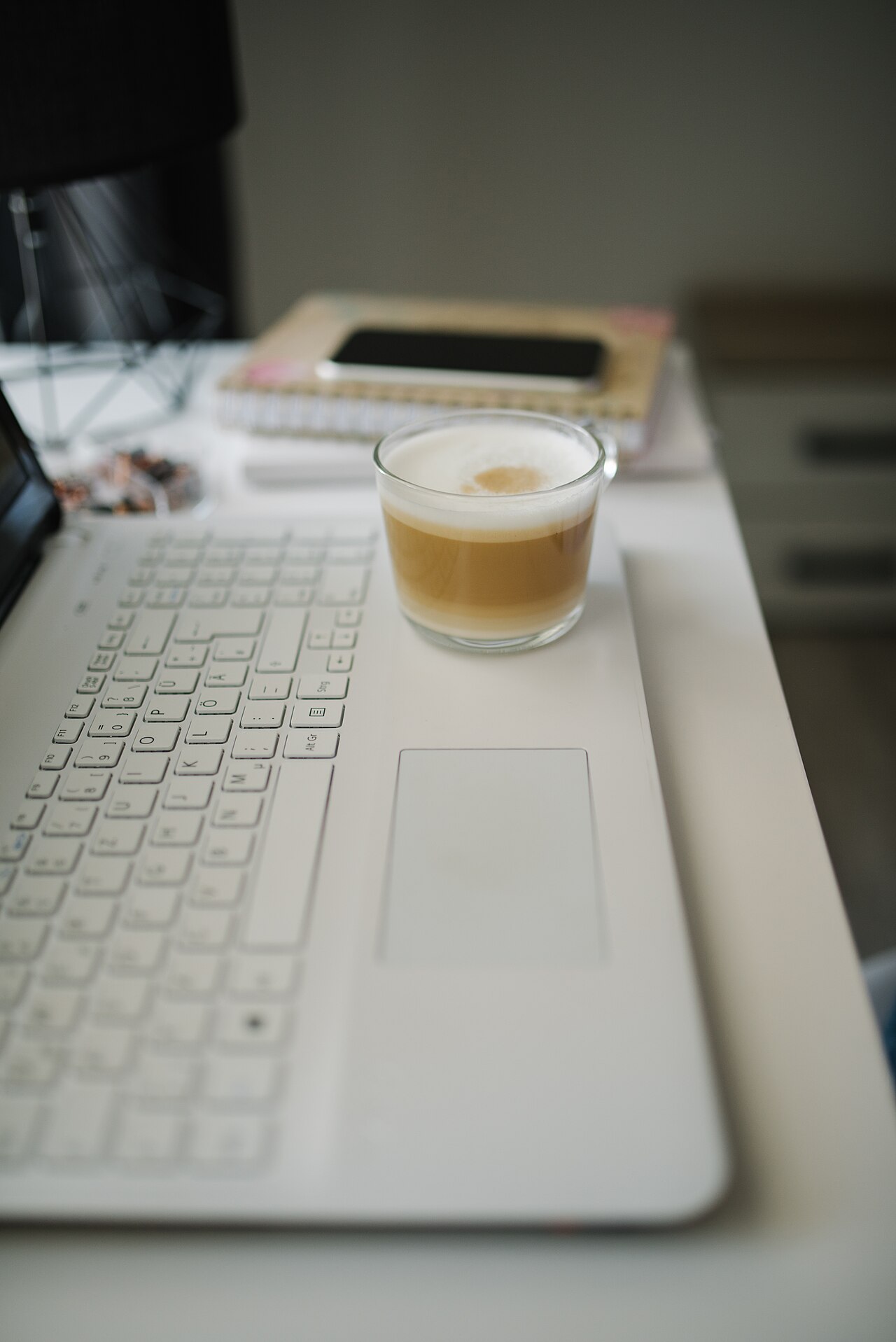 A desk with coffee and a notebook set up for a focused morning work session